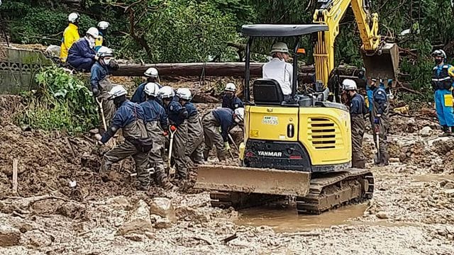 Auf diesem Foto, das von der Nagasaki Kenou Wide Area Fire Department zur Verfügung gestellt wurde, suchen Feuerwehrleute nach schweren Regenfällen in einem Gebiet im Obama-Viertel von Unzen, Präfektur Nagasaki, Südjapan, nach vermissten Personen.