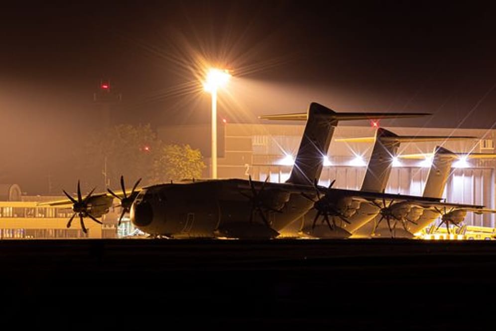 Transportflugzeuge vom Typ Airbus A400M der Luftwaffe stehen am Abend auf dem Fliegerhorst Wunstorf in der Region Hannover hinter einem Zaun.