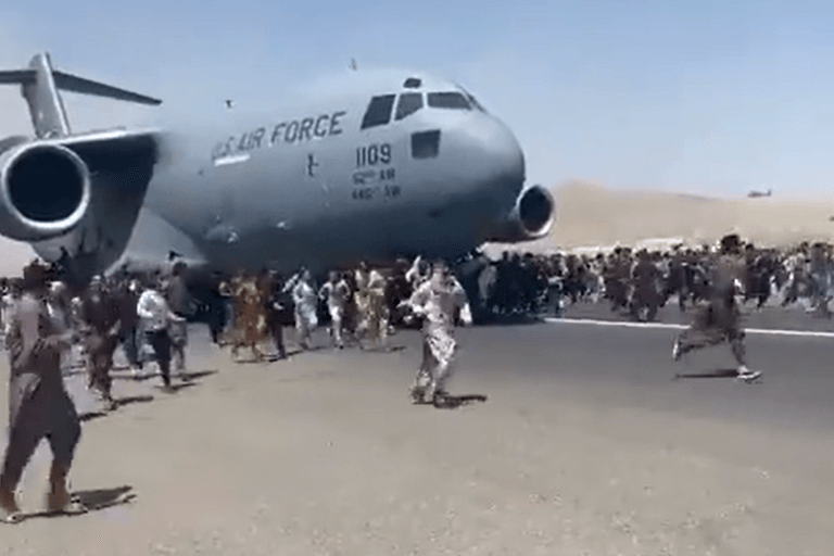 Eine Maschine der US Air Force rollt über den Kabuler Flughafen: Zahlreiche Menschen versuchen, sich an das Flugzeug zu klammern.