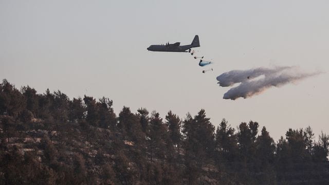 Eine Lockheed C-130 Hercules wirft Löschmittel auf einen Waldbrand westlich von Jerusalem. Eine Lockheed C-130 Hercules wirft Löschmittel auf einen Waldbrand westlich von Jerusalem.