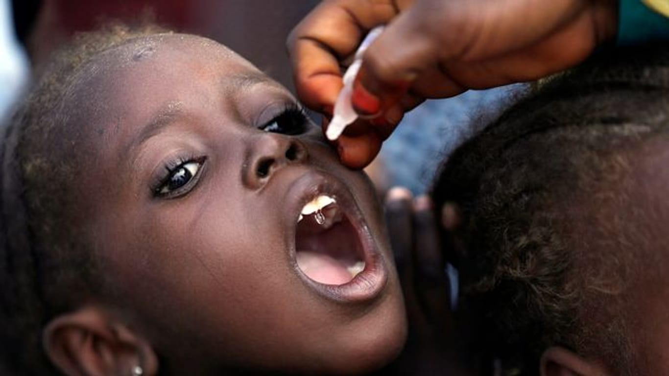 Eine Mitarbeiterin des Gesundheitswesens impft ein kleines Mädchen gegen Polio in einem Lager für Geflüchtete in Nigeria.