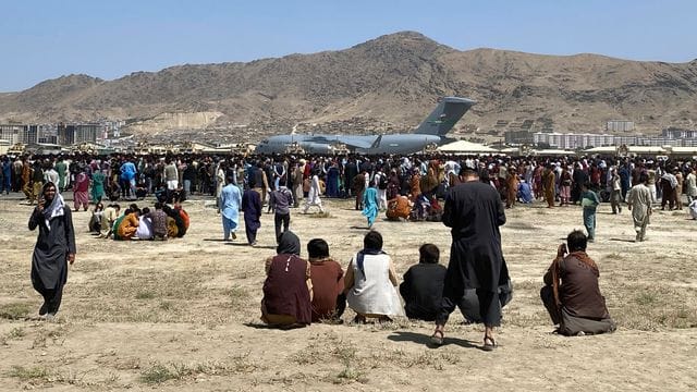 Hunderte Menschen haben sich auf dem Gelände des internationalen Flughafens in Kabul versammelt. Hunderte Menschen haben sich auf dem Gelände des internationalen Flughafens in Kabul versammelt.