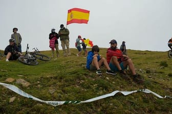 Zuschauer sitzen in der Nähe der Rennstrecke am Straßenrand.