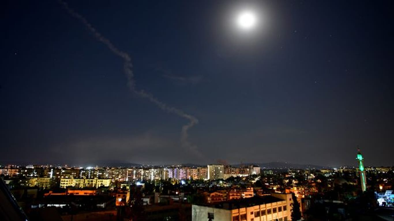 Am Himmel über Damaskus, Syrien, ist die Rauchfahne einer Rakete zu sehen.
