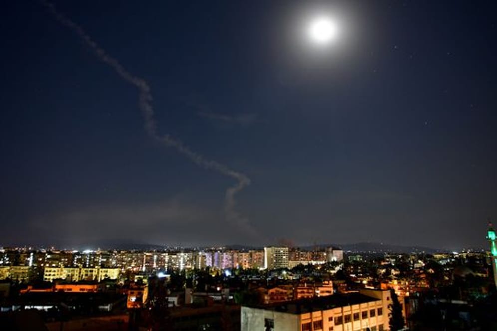 Am Himmel über Damaskus, Syrien, ist die Rauchfahne einer Rakete zu sehen.