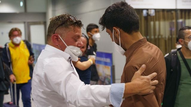 Nagib Saidi (r) aus Kabul wird auf dem Frankfurter Flughafen nach seiner Ankunft ivon seinem Schwiegervater Antioco Onnis (l) begrüßt.