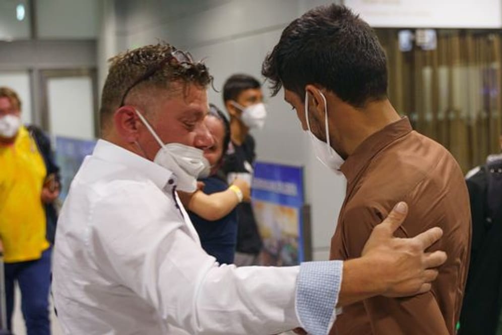 Nagib Saidi (r) aus Kabul wird auf dem Frankfurter Flughafen nach seiner Ankunft ivon seinem Schwiegervater Antioco Onnis (l) begrüßt.