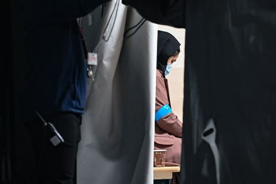 Eine Frau, die zusammen mit weiteren Ortskräften aus Afghanistan am frühen Morgen auf dem Gelände der DRK-Flüchtlingshilfe.
