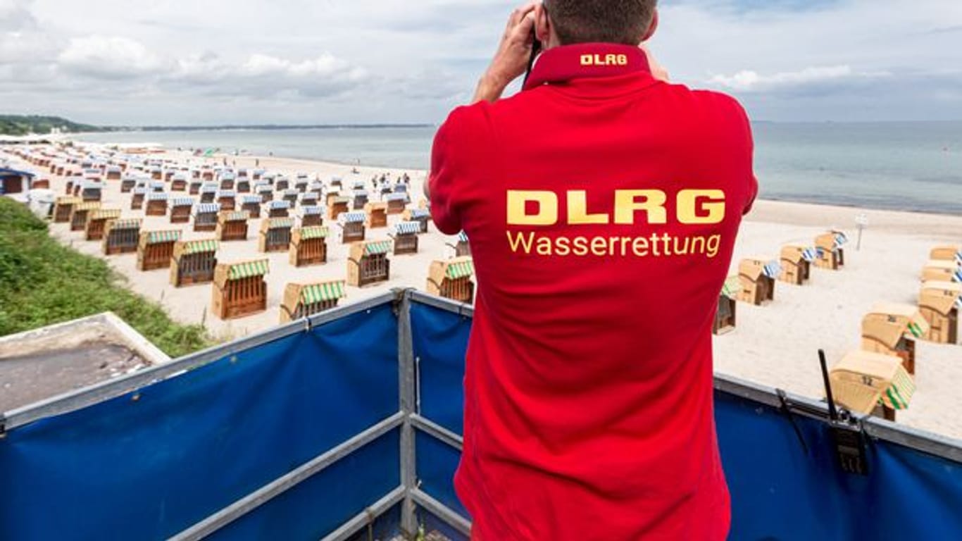 Ein Rettungsschwimmer der Deutsche Lebens-Rettungs-Gesellschaft (DLRG) betrachtet einen Strand.