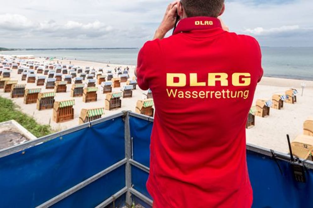 Ein Rettungsschwimmer der Deutsche Lebens-Rettungs-Gesellschaft (DLRG) betrachtet einen Strand.