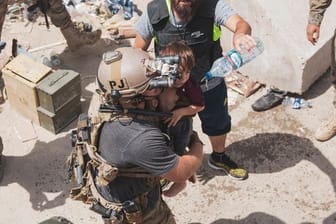 Auf diesem vom US Marine Corps zur Verfügung gestellten Foto trägt ein US-Soldat ein Kind an einem Evakuierungskontrollpunkt am Kabuler Flughafen.