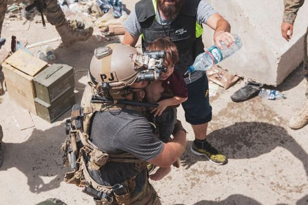 Auf diesem vom US Marine Corps zur Verfügung gestellten Foto trägt ein US-Soldat ein Kind an einem Evakuierungskontrollpunkt am Kabuler Flughafen.
