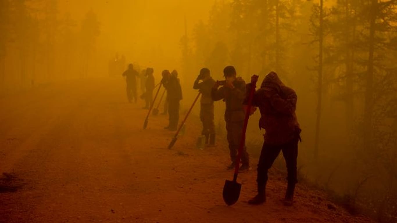 Freiwillige Helfer machen am Ort eines Waldbrands im Gebiet Gorny Ulus westlich von Jakutsk eine Pause.