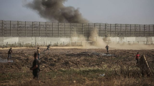 Palästinensische Demonstranten stoßen am Grenzzaun zu Israel mit israelischen Sicherheitskräften zusammen.