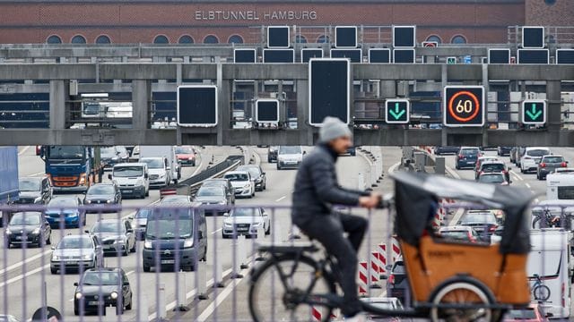 Ein Lastenrad-Fahrer fährt über eine Brücke über der Autobahn 7 in Hamburg.