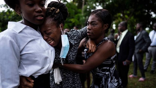 Eine Frau weint während der Beerdigung eines Angehörigen in Les Cayes, der bei dem Erdbeben ums Leben kam. Eine Frau weint während der Beerdigung eines Angehörigen in Les Cayes, der bei dem Erdbeben ums Leben kam.