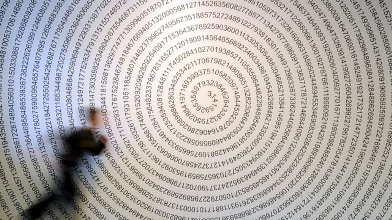 Ein Schulkind läuft im Gießener Mitmachmuseum "Mathematikum" an der Kreiszahl Pi vorbei.