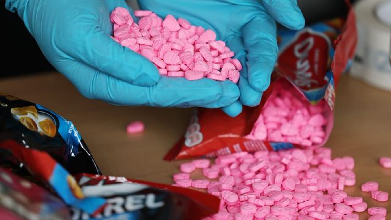 Ein Zollbeamter hält Ecstasy Tabletten in der Hand, die am Flughafen Köln/Bonn sichergestellt wurden.