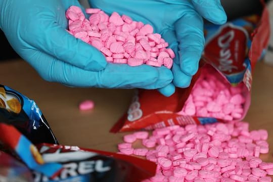 Ein Zollbeamter hält Ecstasy Tabletten in der Hand, die am Flughafen Köln/Bonn sichergestellt wurden.