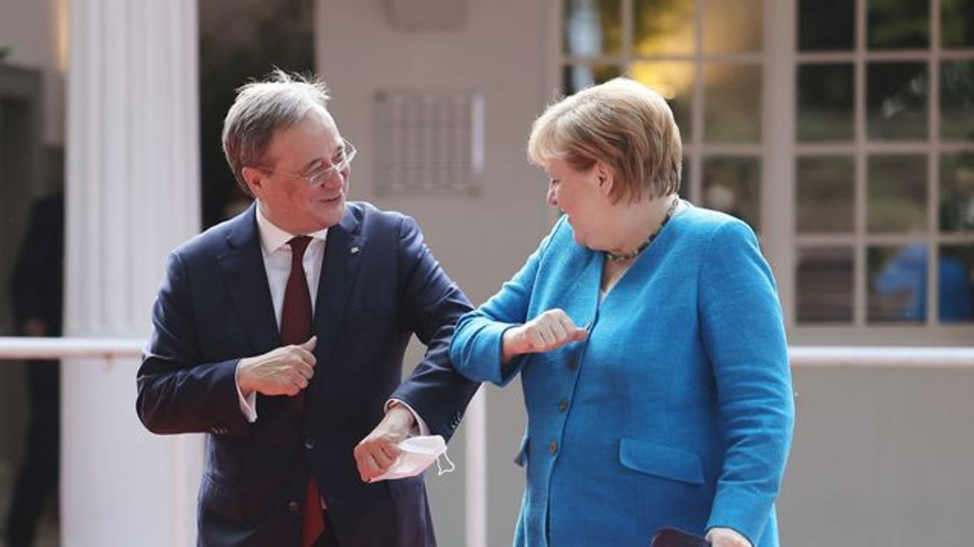 Armin Laschet und Angela Merkel begrüßen sich beim Festakt zum NRW-Landesgeburtstag.