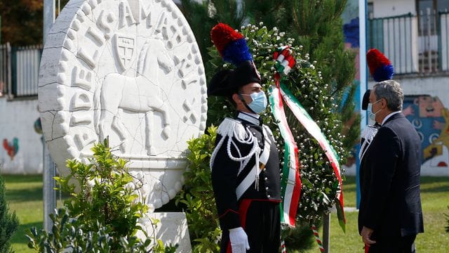 Premierminister Draghi vor dem Denkmal für die Opfer des Erdbebens in Amatrice.