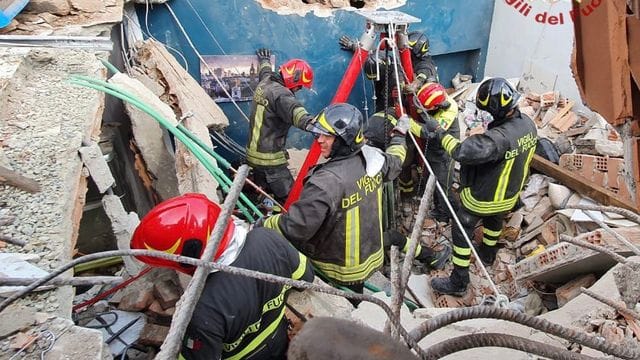 Rettungskräfte der Feuerwehr vor dem eingestürzten Wohnhaus in Turin.