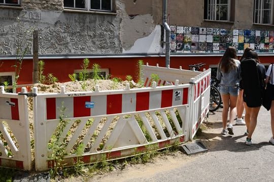 Absperrungen vor einer maroden Wand an einer Berliner Schule.
