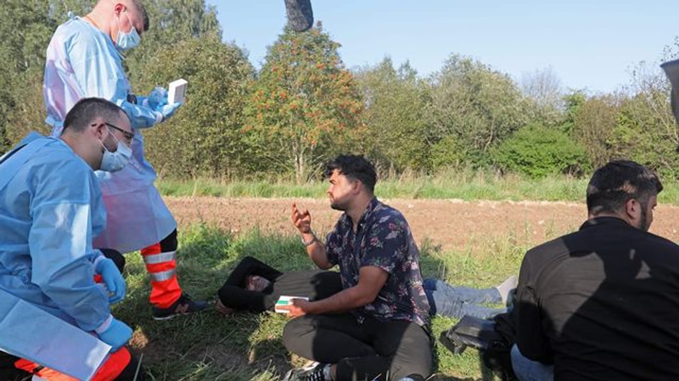 Sanitäter sprechen mit der Gruppe von Flüchtlingen an der polnisch-belarussischen Grenze.