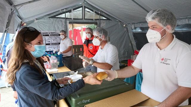 Helfer vom Roten Kreuz geben in Ahrweiler Essen aus. Helfer vom Roten Kreuz geben in Ahrweiler Essen aus.