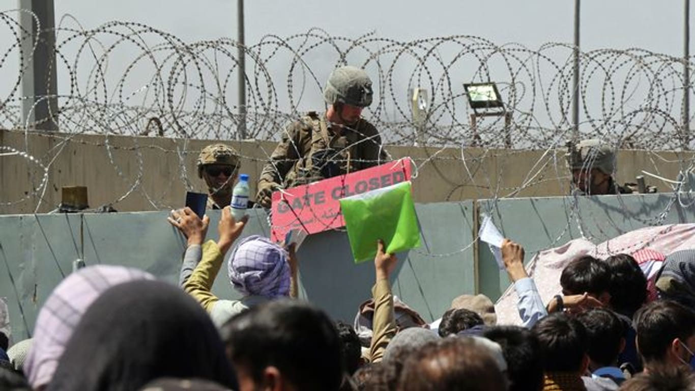 Hunderte Menschen hoffen vor einem Evakuierungskontrollpunkt auf dem Gelände des Flughafens von Kabul darauf, außer Landes zu gelangen.