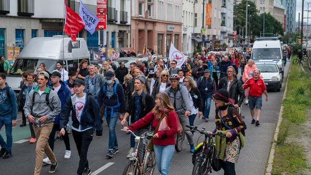 Aus Protest gegen die Corona-Politik wandern Demonstranten durch eine Straße.