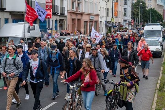 Aus Protest gegen die Corona-Politik wandern Demonstranten durch eine Straße.
