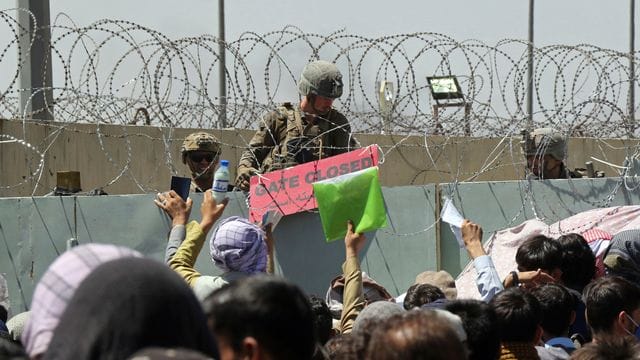 Hunderte von Menschen in der Nähe eines Evakuierungskontrollpunkts auf dem Gelände des Flughafens Kabul. Hunderte von Menschen in der Nähe eines Evakuierungskontrollpunkts auf dem Gelände des Flughafens Kabul.