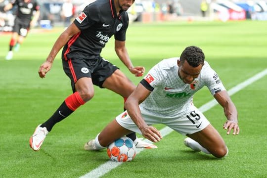 Frankfurts Djibril Sow (l) und Augsburgs Felix Uduokhai kämpfen um den Ball.