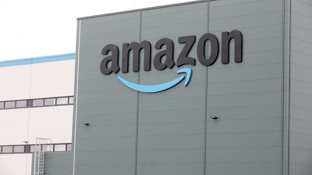 Das Amazon-Logo ist auf einer Baustelle zu sehen (Symbolbild): Die Fahrer und Zusteller fordern bessere Kontrollen der Arbeitsbedingungen. Das Amazon-Logo ist auf einer Baustelle zu sehen (Symbolbild): Die Fahrer und Zusteller fordern bessere Kontrollen der Arbeitsbedingungen.