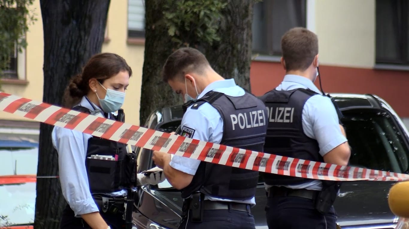Polizisten stehen hinter Absperrband auf der Röntgenstraße: Eine Frau wurde hier mit einem Messer lebensgefährlich verletzt.