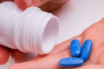 Eine Person schüttet Tabletten aus einer Dose in die Hand (Symbolbild): Besonders mit Beruhigungsmitteln soll ein Duo aus Ansbach einen illegalen Drogenhandel betrieben haben.
