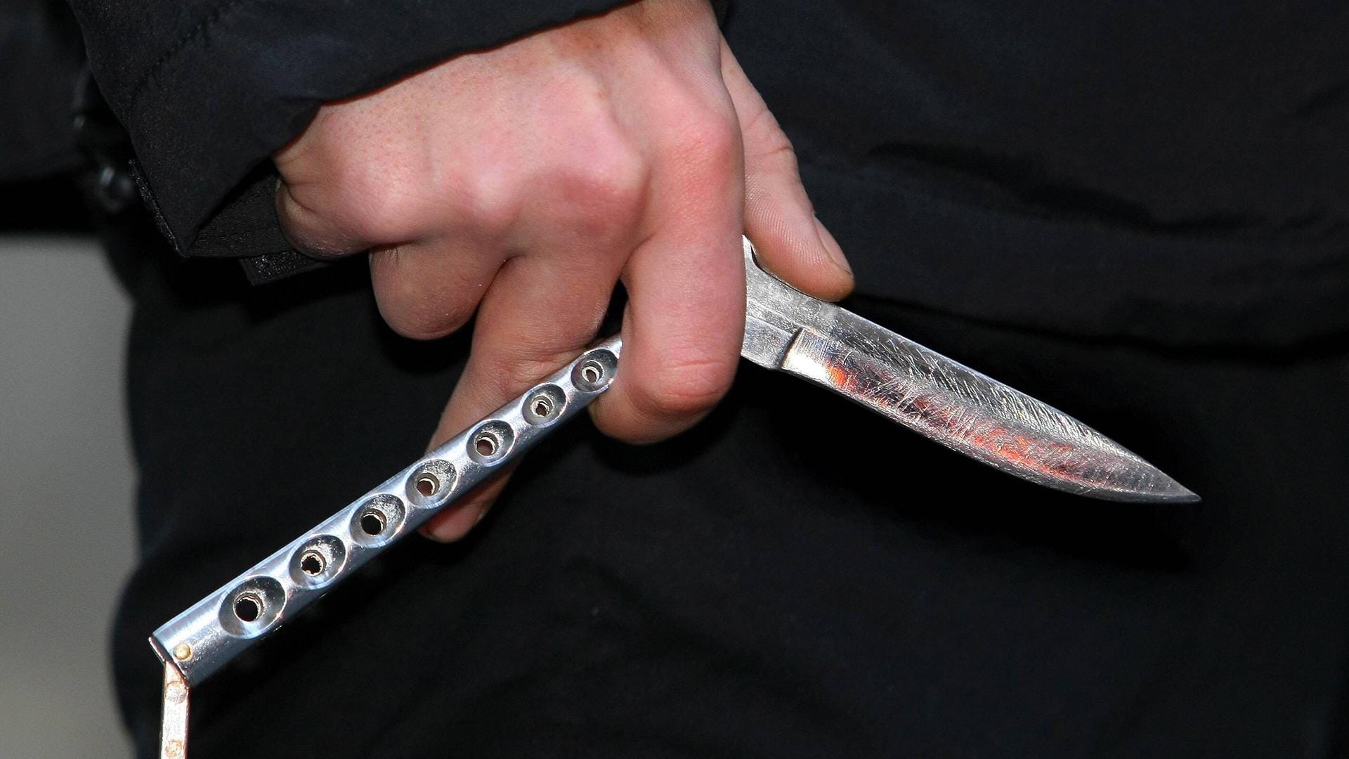 Ein Jugendlicher hält ein Butterflymesser in der Hand (Symbolbild): Eine ähnliche Waffe fanden die Beamten bei dem Jungen.