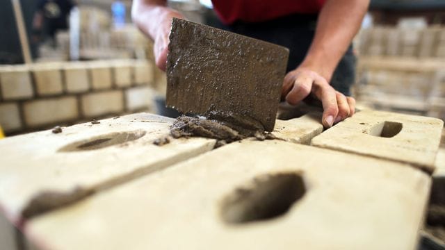 Ein Maurer-Azubi arbeitet im Ausbildungszentrum an einer Mauer