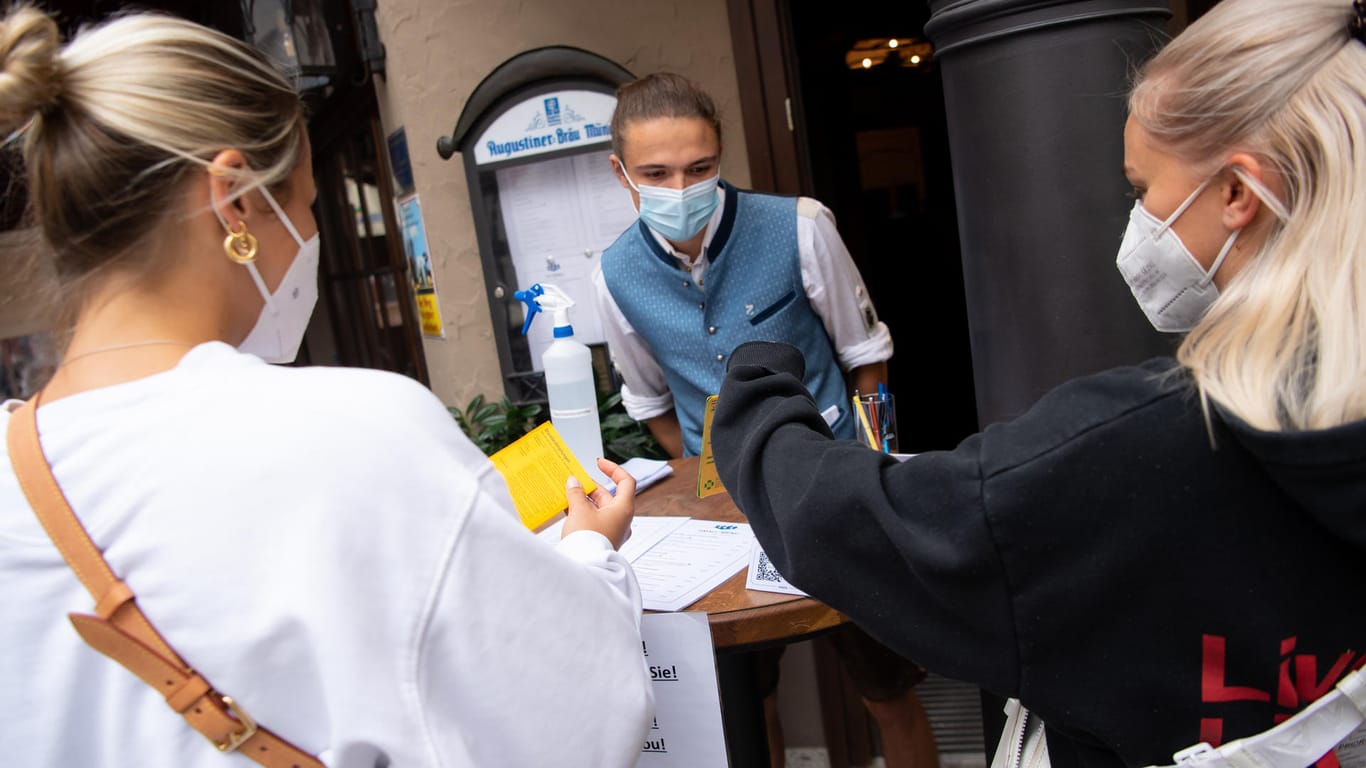 Ein Gasthaus-Mitarbeiter kontrolliert Impfpässe in München: Sollen das künftig auch Arbeitgeber dürfen?