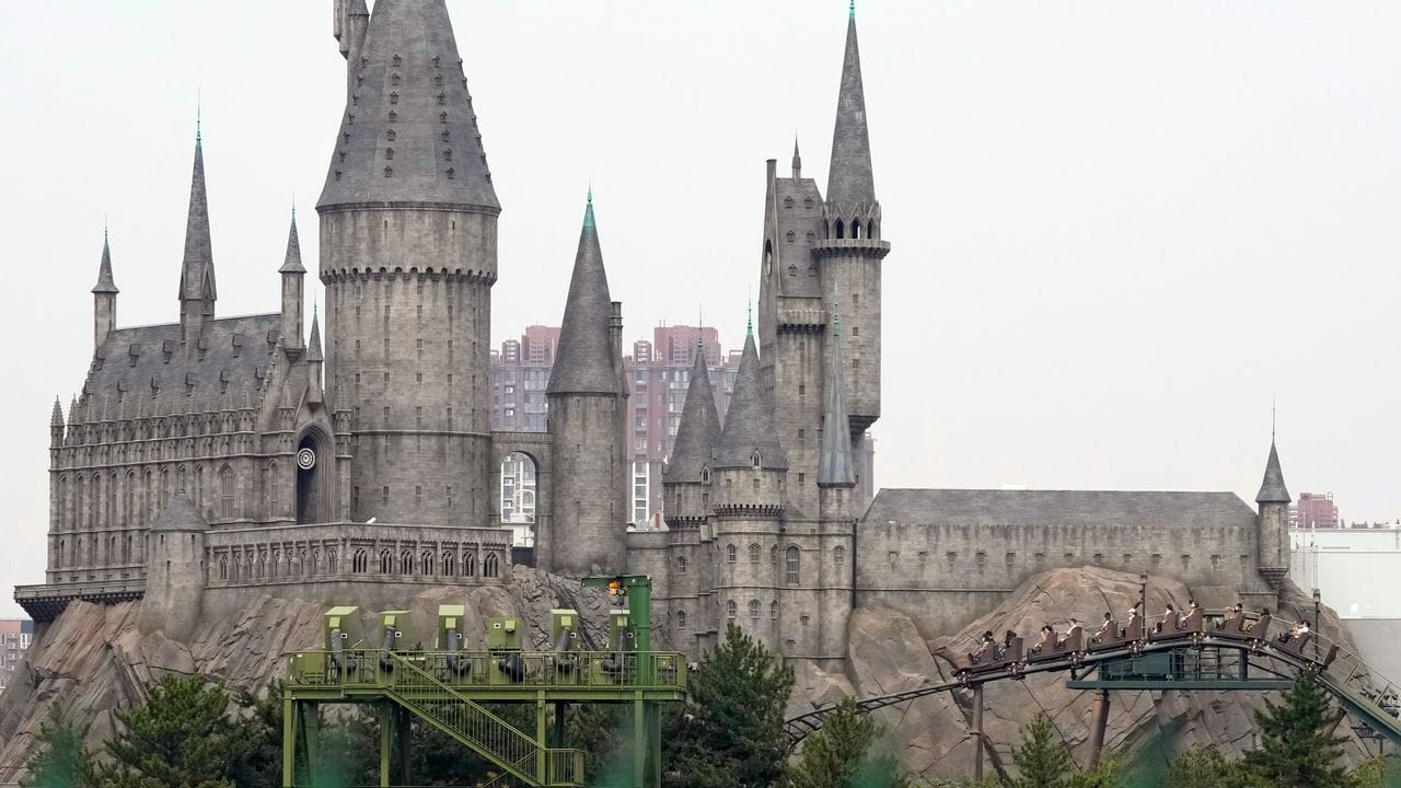 Besucher fahren im Vergnügungspark von Universal Studios im Rahmen eines Probelaufs auf einer Achterbahn. Besucher fahren im Vergnügungspark von Universal Studios im Rahmen eines Probelaufs auf einer Achterbahn.