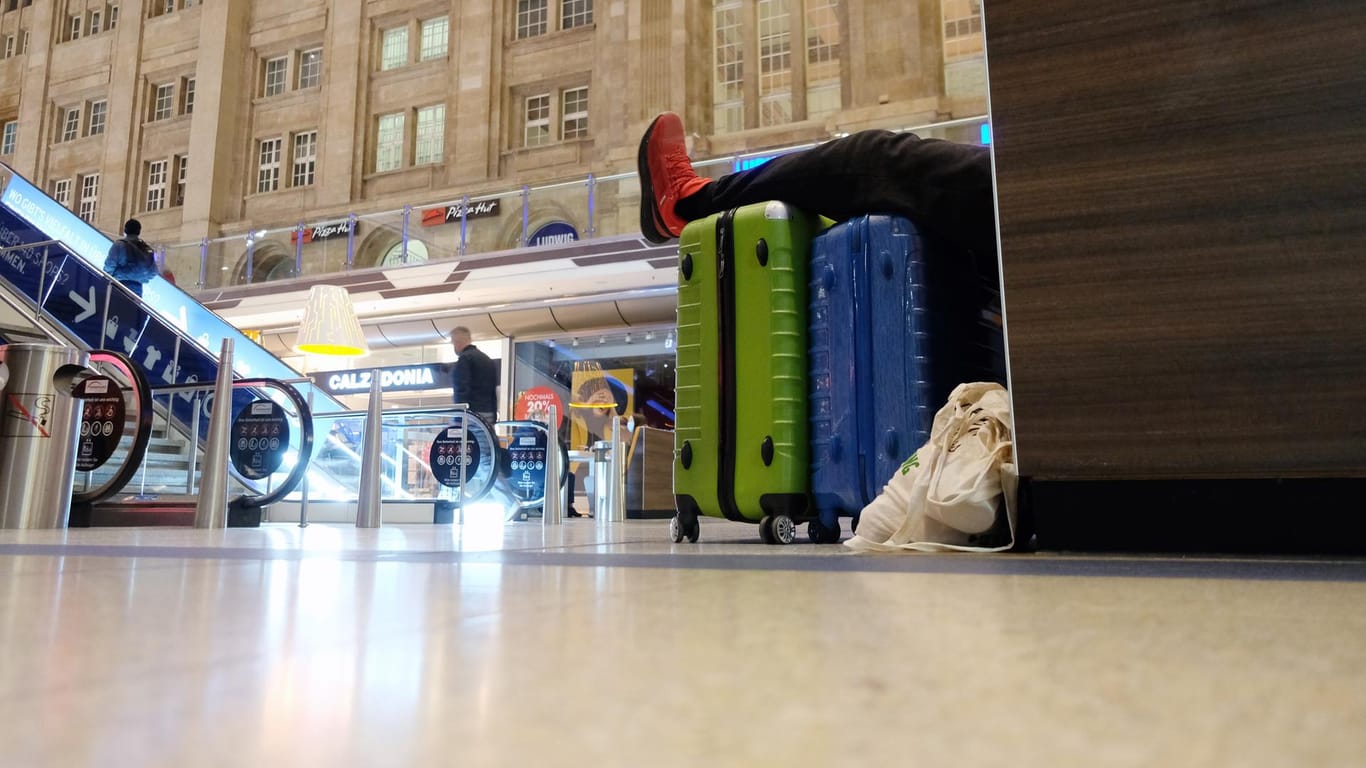 Ein Reisender liegt auf einer Sitzgelegenheit im Leipziger Hauptbahnhof: Hier nehmen viele Reisende den erneuten GDL-Streik gelassen.