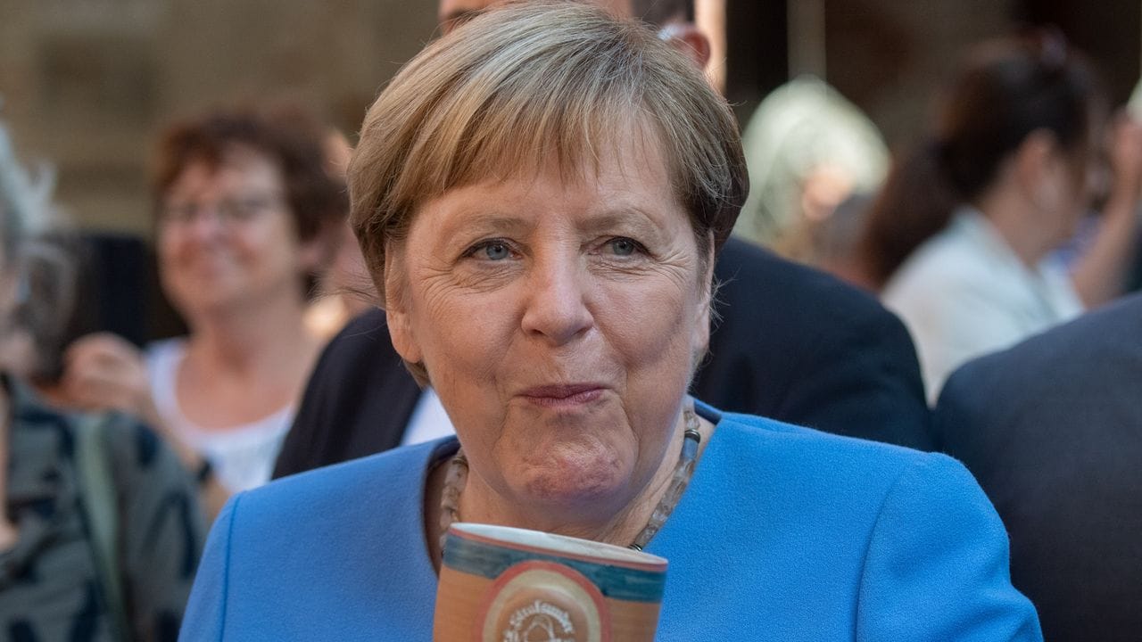 Bundeskanzlerin Angela Merkel (CDU) trinkt bei der Stralsunder Stadtwache ein Bier.