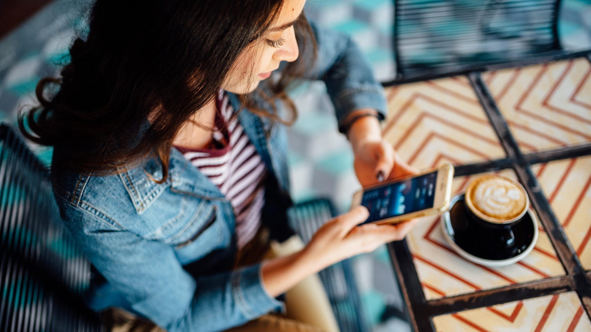 Eine Frau handelt am Smartphone mit Aktien (Symbolbild): Geld, das Sie in Wertpapiere stecken, zählt zum Sondervermögen.