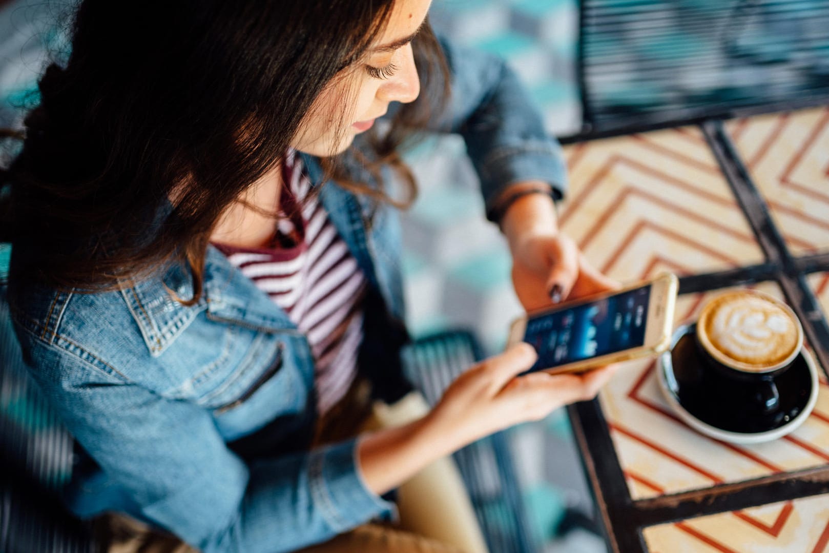 Eine Frau handelt am Smartphone mit Aktien (Symbolbild): Geld, das Sie in Wertpapiere stecken, zählt zum Sondervermögen.