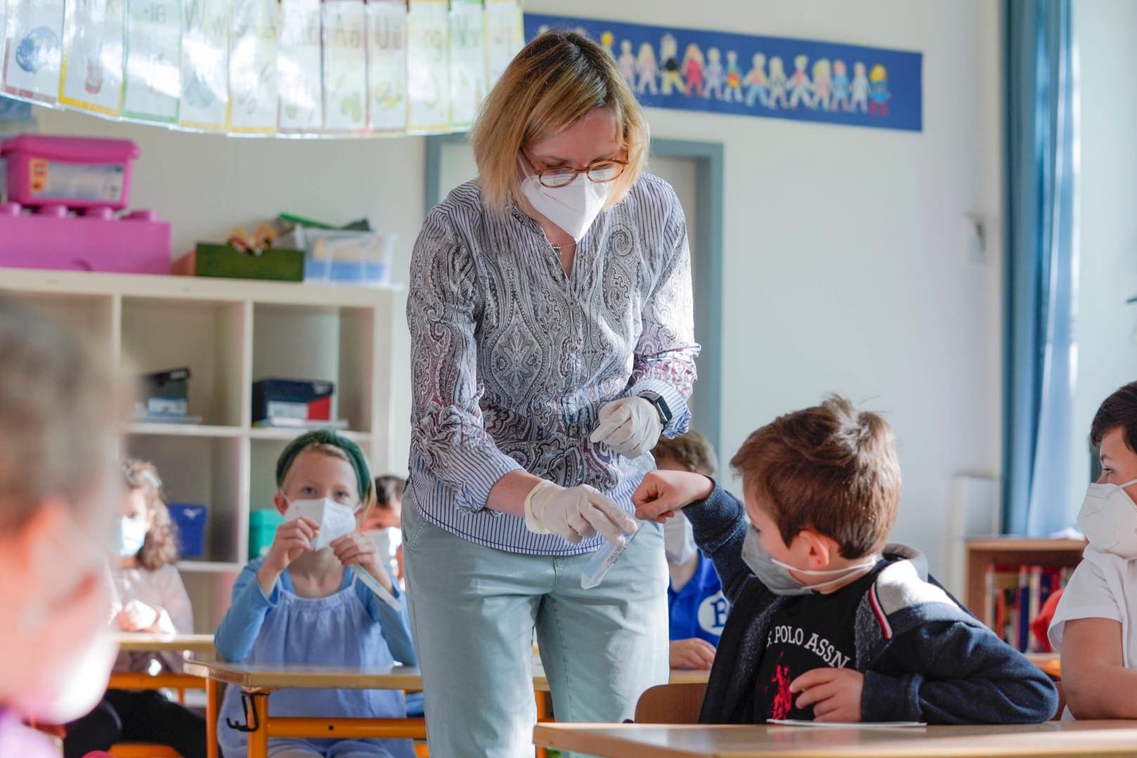 Lehrerin verteilt Corona-Tests: Die Gewerkschaften für Schulen und Kitas sind gegen die neue Maßnahme (Symbolbild).