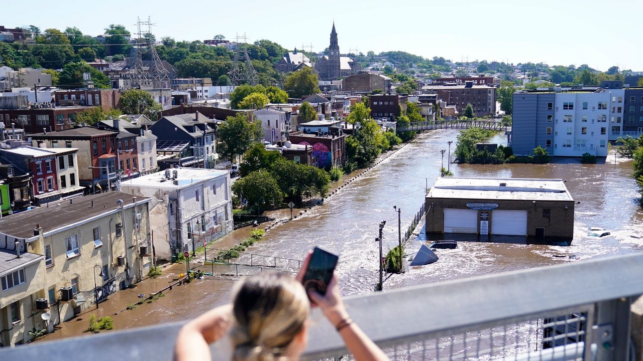 Eine Frau fotografiert das Hochwasser in Philadelphia.