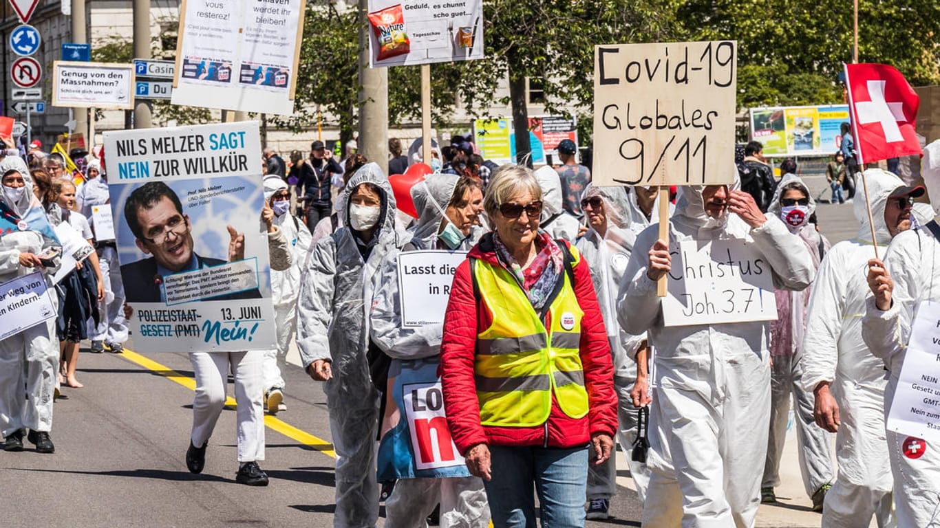 Mit Plakat des UN-Folterbeauftragten: Gegner der Corona-Maßnahmen in der Schweiz tragen bei einer Demo das Konterfei von Melzer. Ein neues Polizeimaßnahmengesetz hat dort die Stimmung zusätzlich angeheizt.