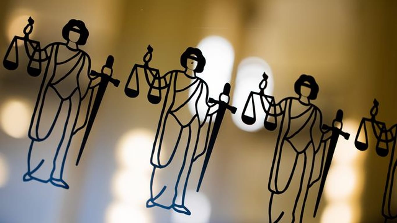 Die Justitia ist an einer Scheibe am Eingang zum Oberlandesgericht zu sehen (Symbolbild): Einem der Nageklagten werden 18 Fälle vorgeworfen, einem weiteren 13.