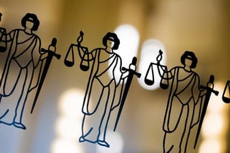 Die Justitia ist an einer Scheibe am Eingang zum Oberlandesgericht zu sehen (Symbolbild): Einem der Nageklagten werden 18 Fälle vorgeworfen, einem weiteren 13.